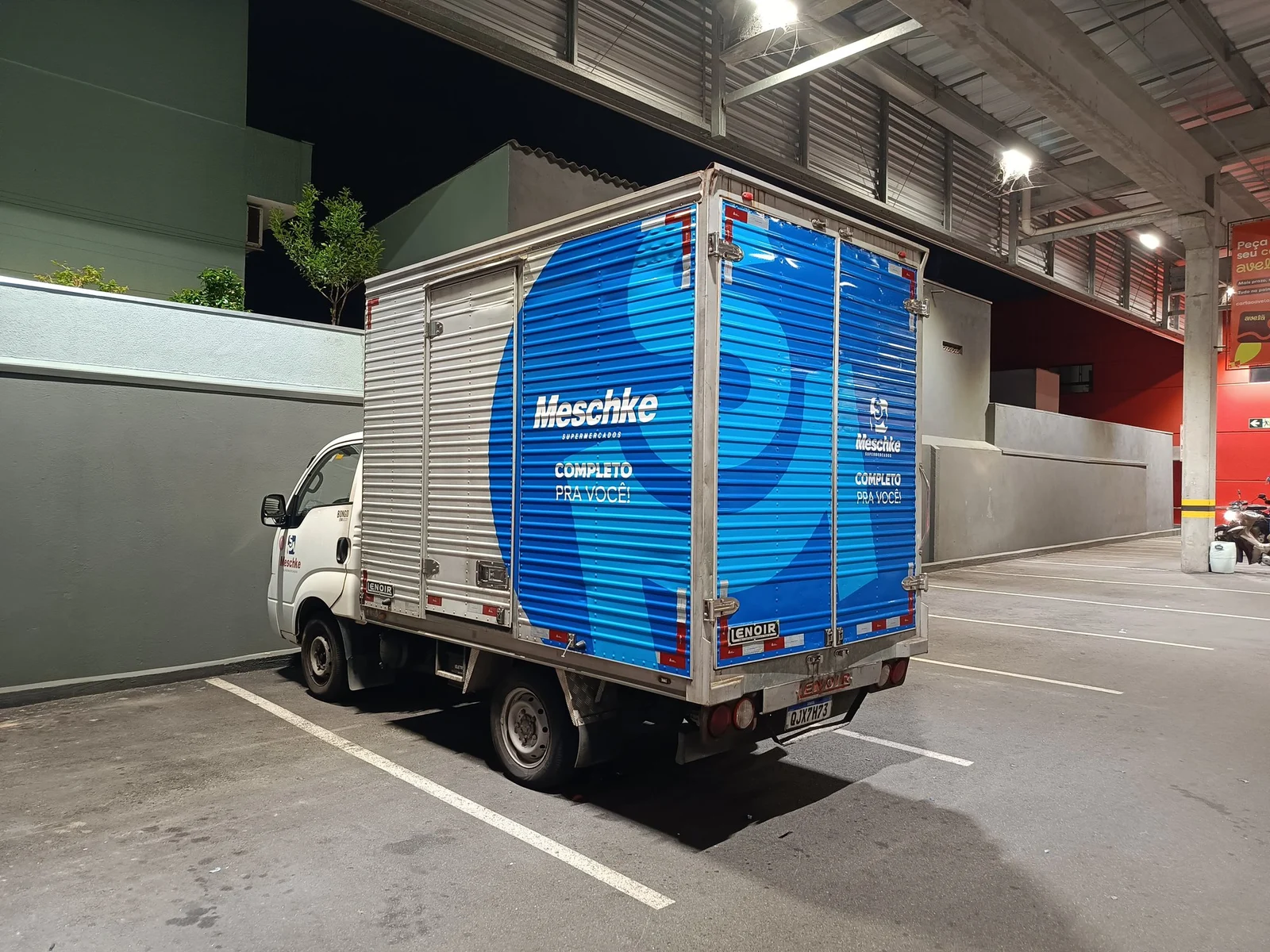 Baú de caminhão adesivado com a identidade da empresa, levando a marca por onde passa.