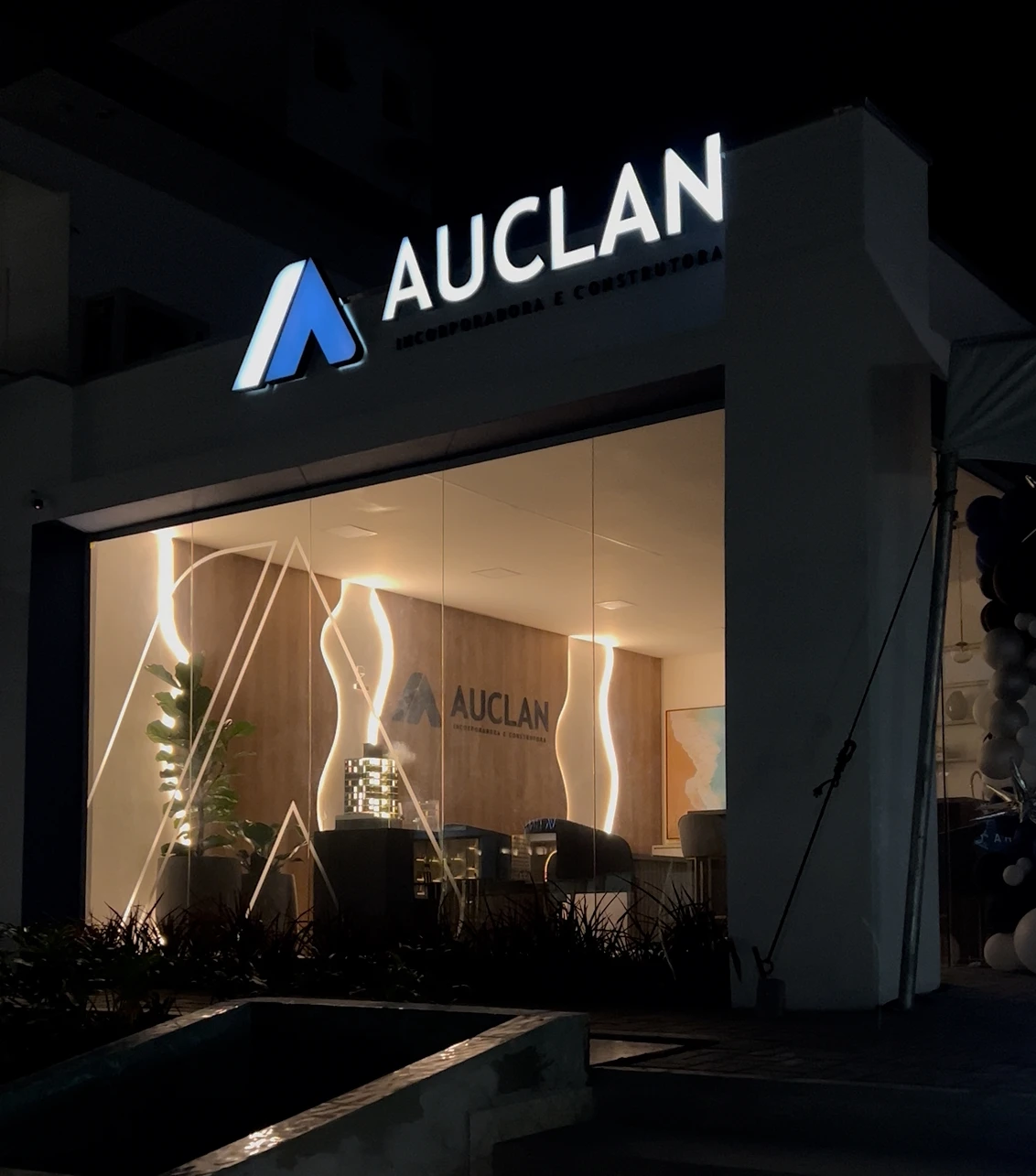 Fachada da Auclan à noite com letreiro iluminado produzido pela Divulga