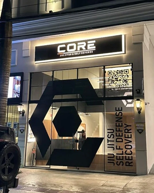 Fachada da CORE à noite com letreiro iluminado